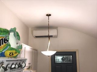 A room with a ceiling fan and a chandelier hanging from it.