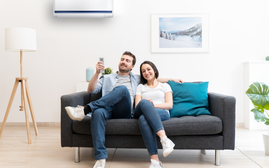 man and woman sitting on the couch turning on air conditioner