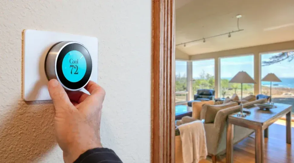 A person is adjusting a thermostat in a living room