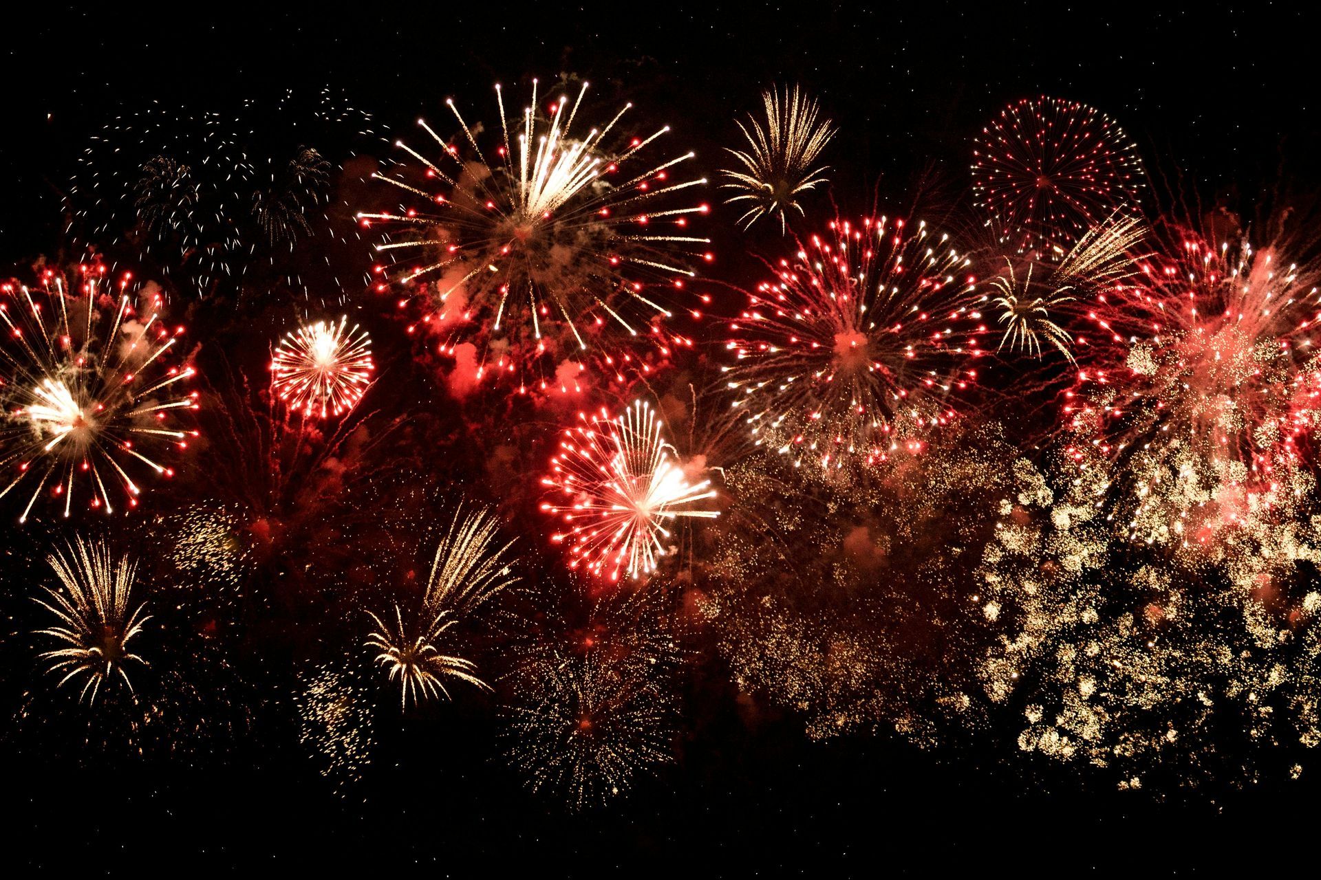 A bunch of fireworks are going off in the night sky
