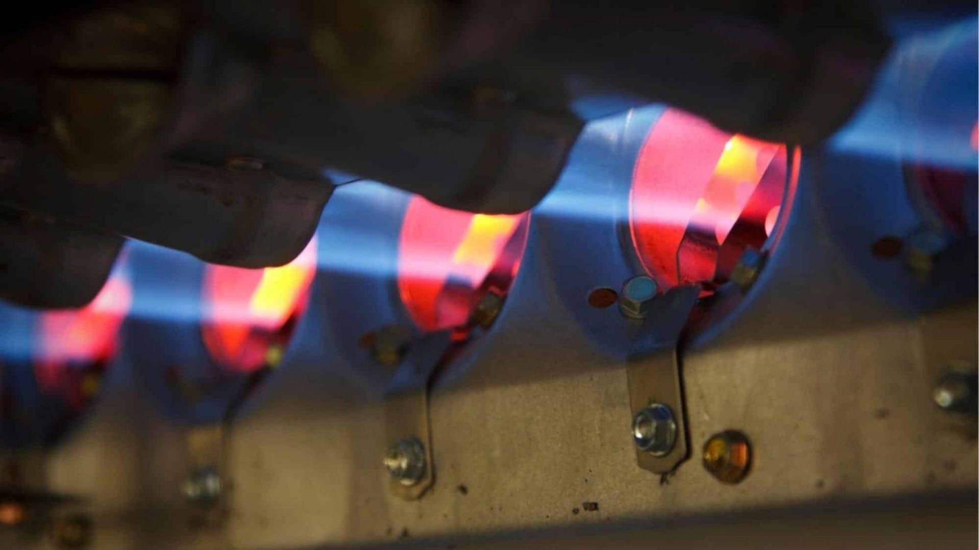 Blue flames with red centers burning in a furnace.