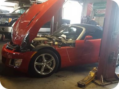 Red car with lifted hood | Madden Auto Repair