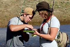 A man and a woman are fishing in a river.