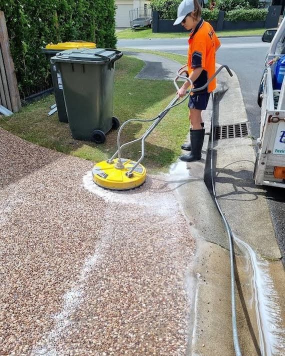 Woman Cleaning a Driveway With Pressure Washer — Excess Cleaning in Molendinar, QLD