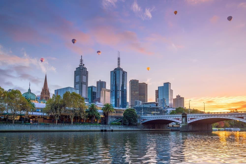 A City Skyline With Hot Air Balloons Flying Over It at Sunset — Excess Cleaning in Melbourne City, VIC