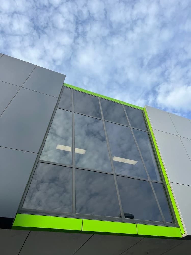 A Building With a Lot of Windows and a Blue Sky in the Background — Excess Cleaning in Molendinar, QLD