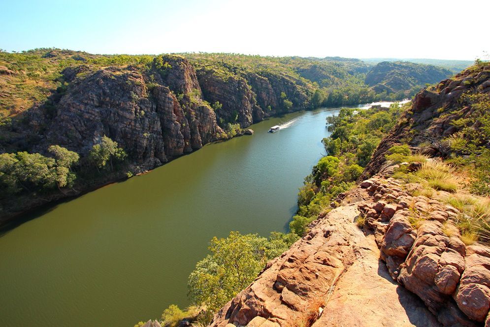 A Boat is Going Down a River Surrounded by Rocks and Trees — Excess Cleaning in Northern Rivers, NSW