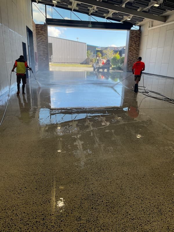 Men Cleaning Concrete Floor in a Warehouse — Excess Cleaning in Molendinar, QLD