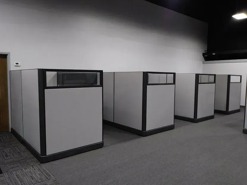 A row of cubicles are lined up in an office.