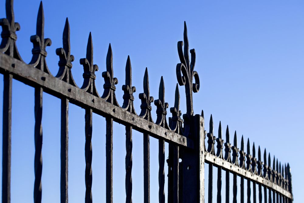 A Wrought Iron Fence With a Blue Sky in the Background — SMH Valley Fencing & Maintenance In Millfield, NSW