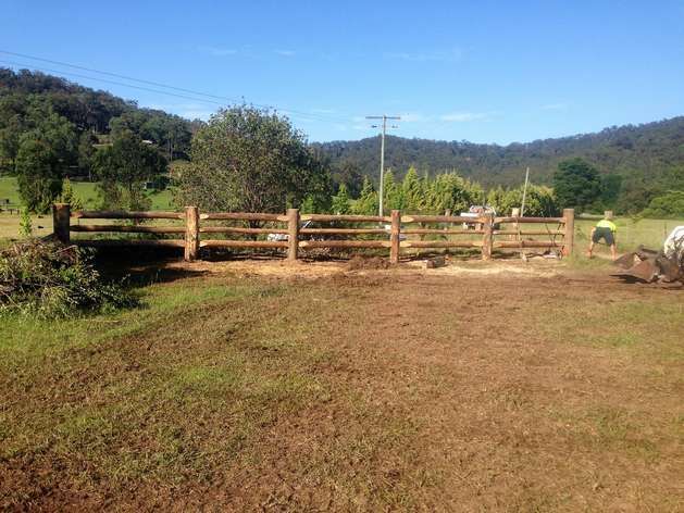 A Wooden Fence is in the Middle of a Grassy Field — SMH Valley Fencing & Maintenance In Millfield, NSW