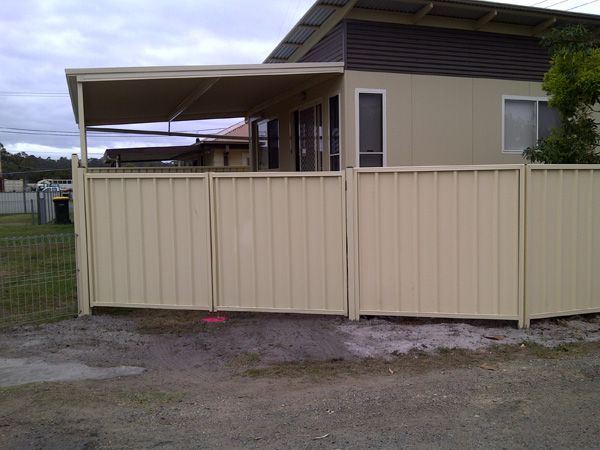 A House With a Fence in Front of It — SMH Valley Fencing & Maintenance In Millfield, NSW