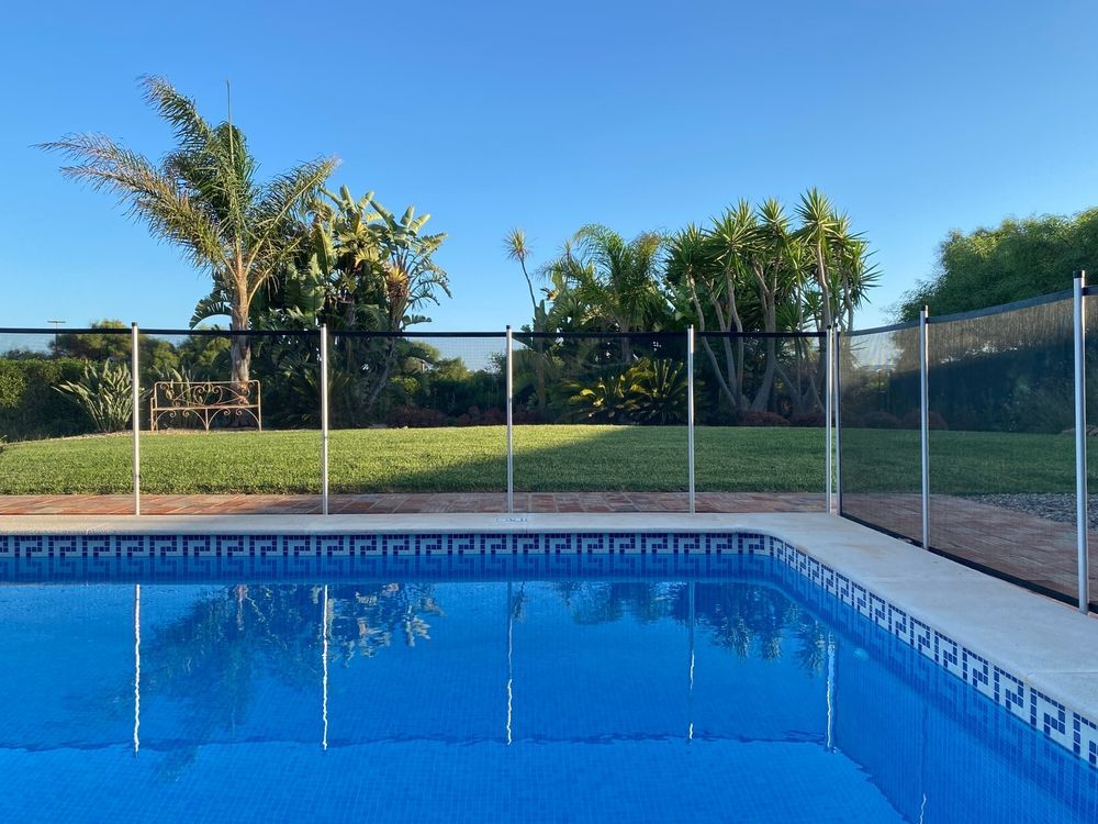 A Large Swimming Pool With a Fence Around It — SMH Valley Fencing & Maintenance In Millfield, NSW
