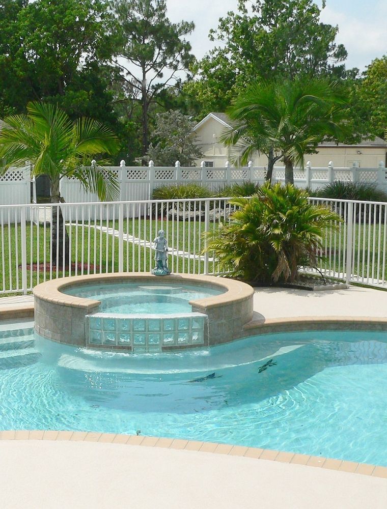 A Large Swimming Pool Surrounded by Palm Trees and a White Fence — SMH Valley Fencing & Maintenance In Millfield, NSW