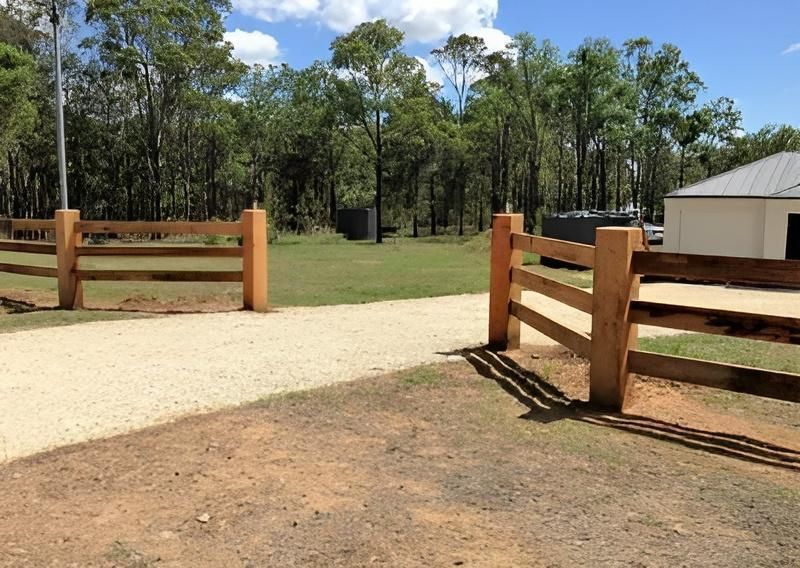 A Fence is Surrounding a Grassy Field With Trees in the Background — SMH Valley Fencing & Maintenance In Cessnock, NSW