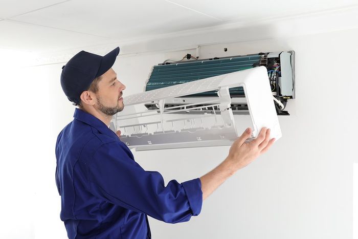 worker intalling the aircon cover