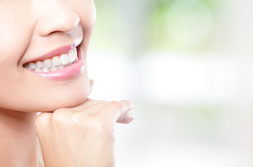 A Close Up Of A Woman 's Smile With Her Hand On Her Chin — Regal's Dental In Yeppoon, QLD
