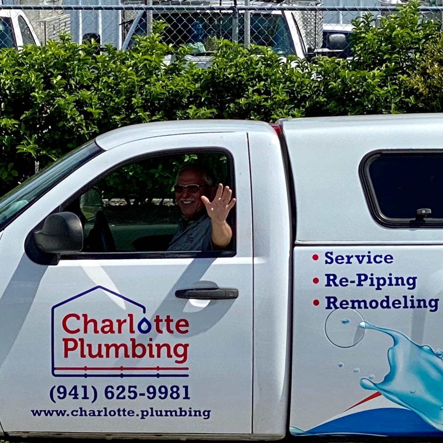 A Plumber Man Waving From The Charlotte Company Car — Port Charlotte, FL — Charlotte Plumbin