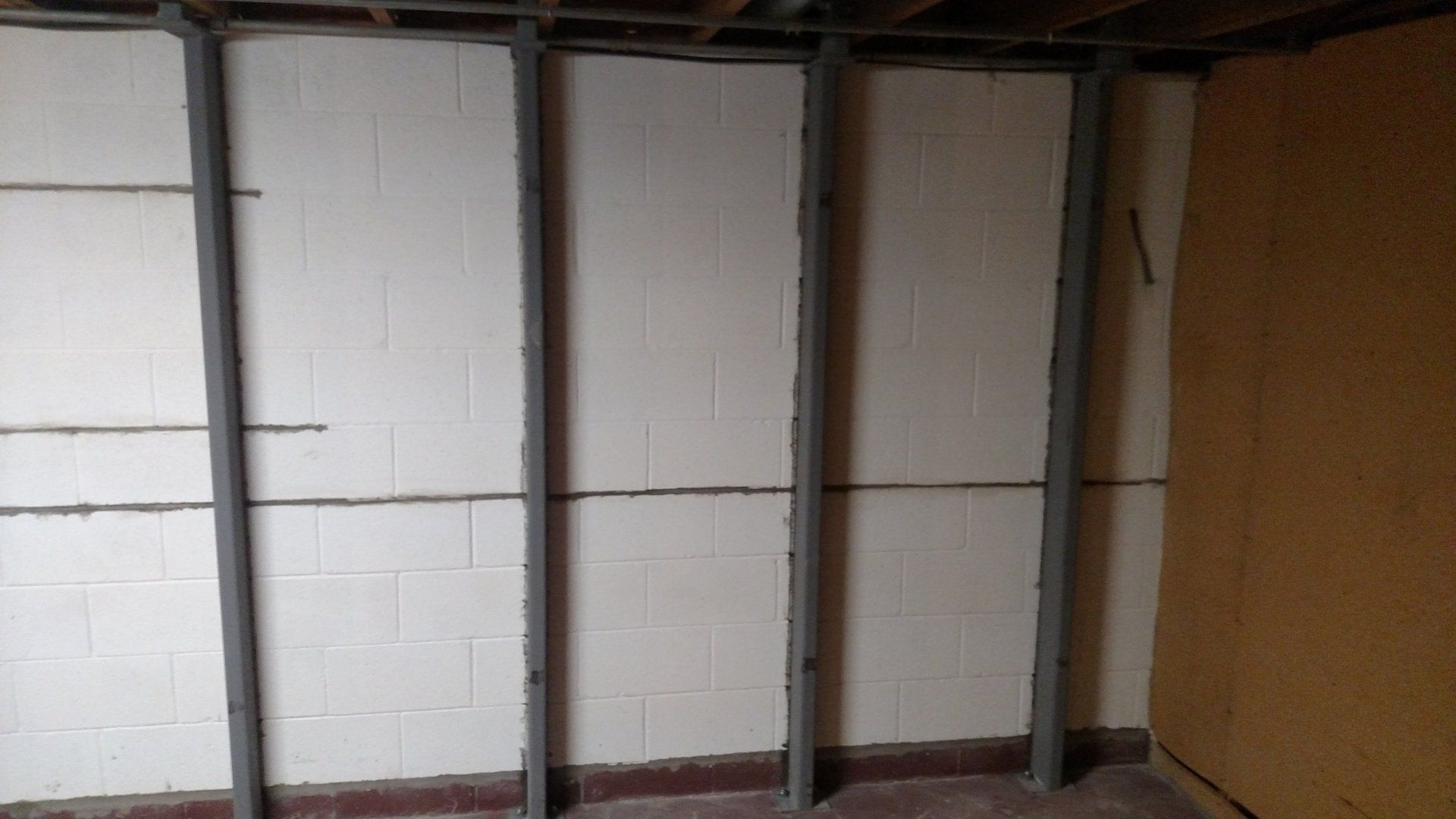 basement paint A room with a brick wall and a metal frame.