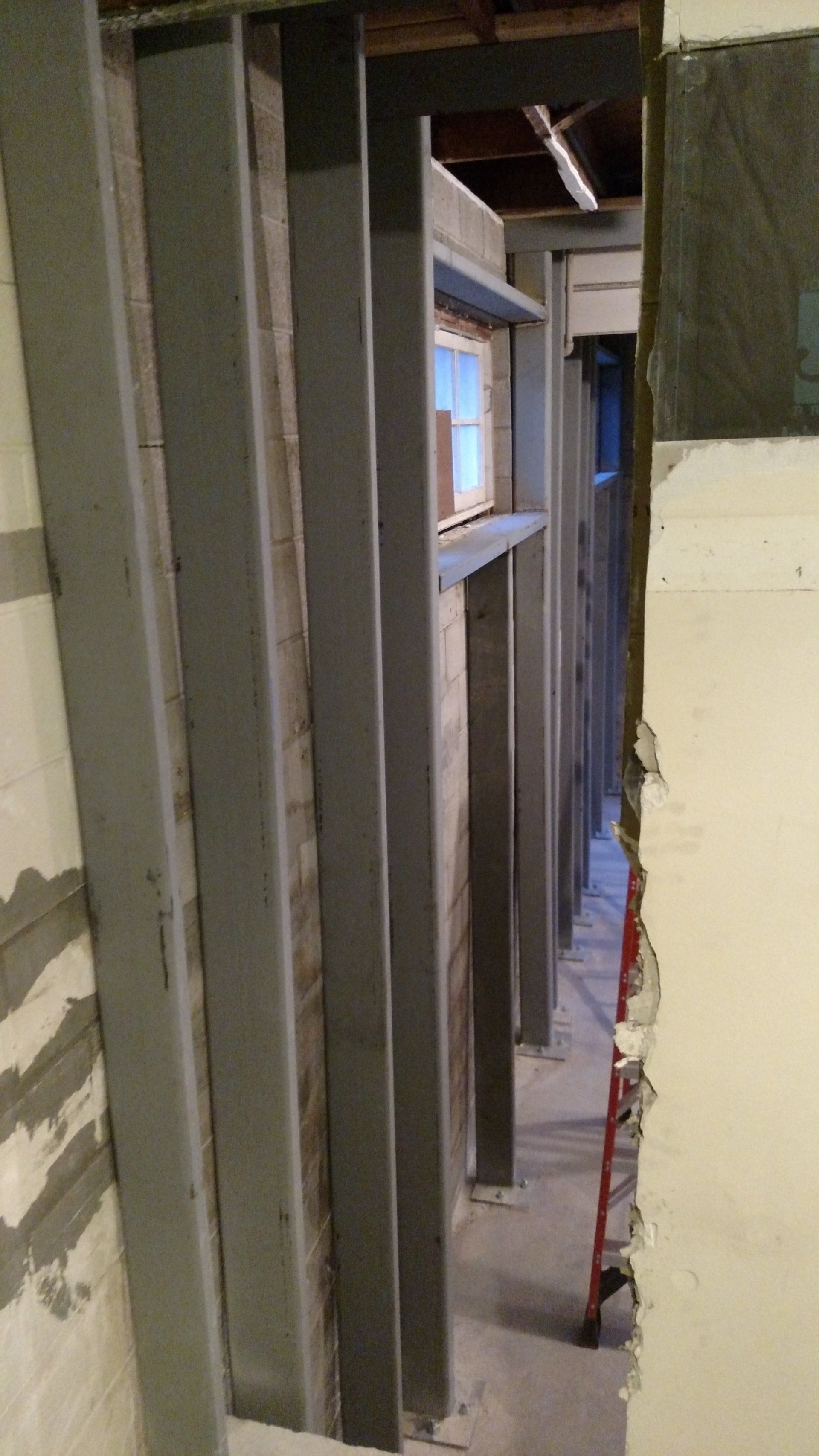 basement foundation repair near me A narrow hallway with a ladder in the middle of it.