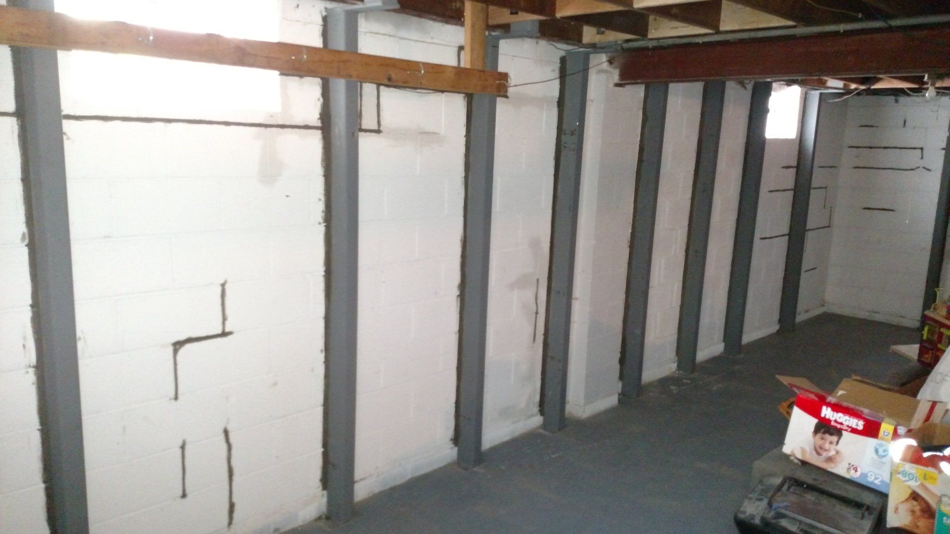 cracks in foundation A basement with a lot of boxes on the floor and a window.