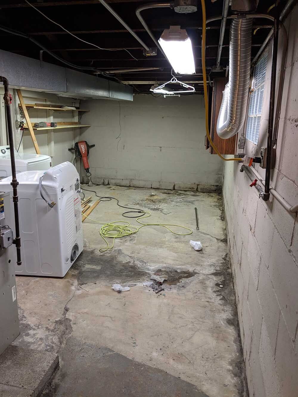 cracks in basement floor A laundry room with a washer and dryer in it.