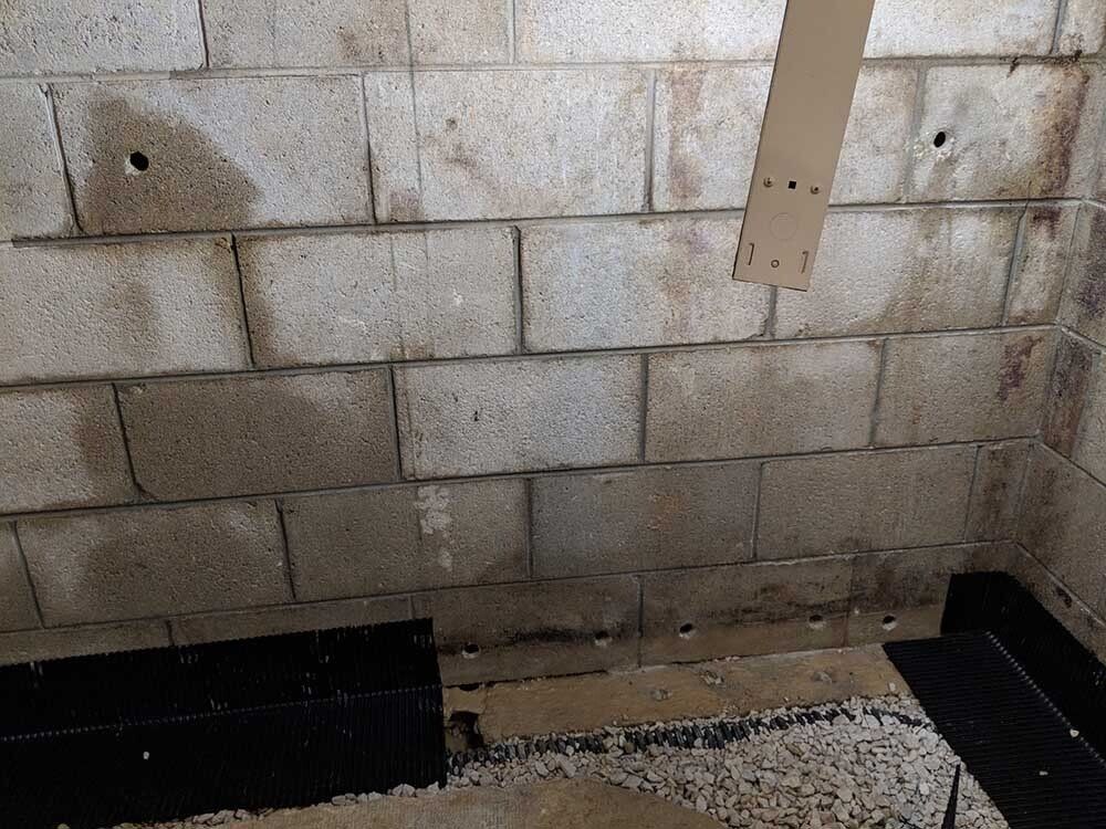 leaky basement A brick wall with a hole in the middle of it