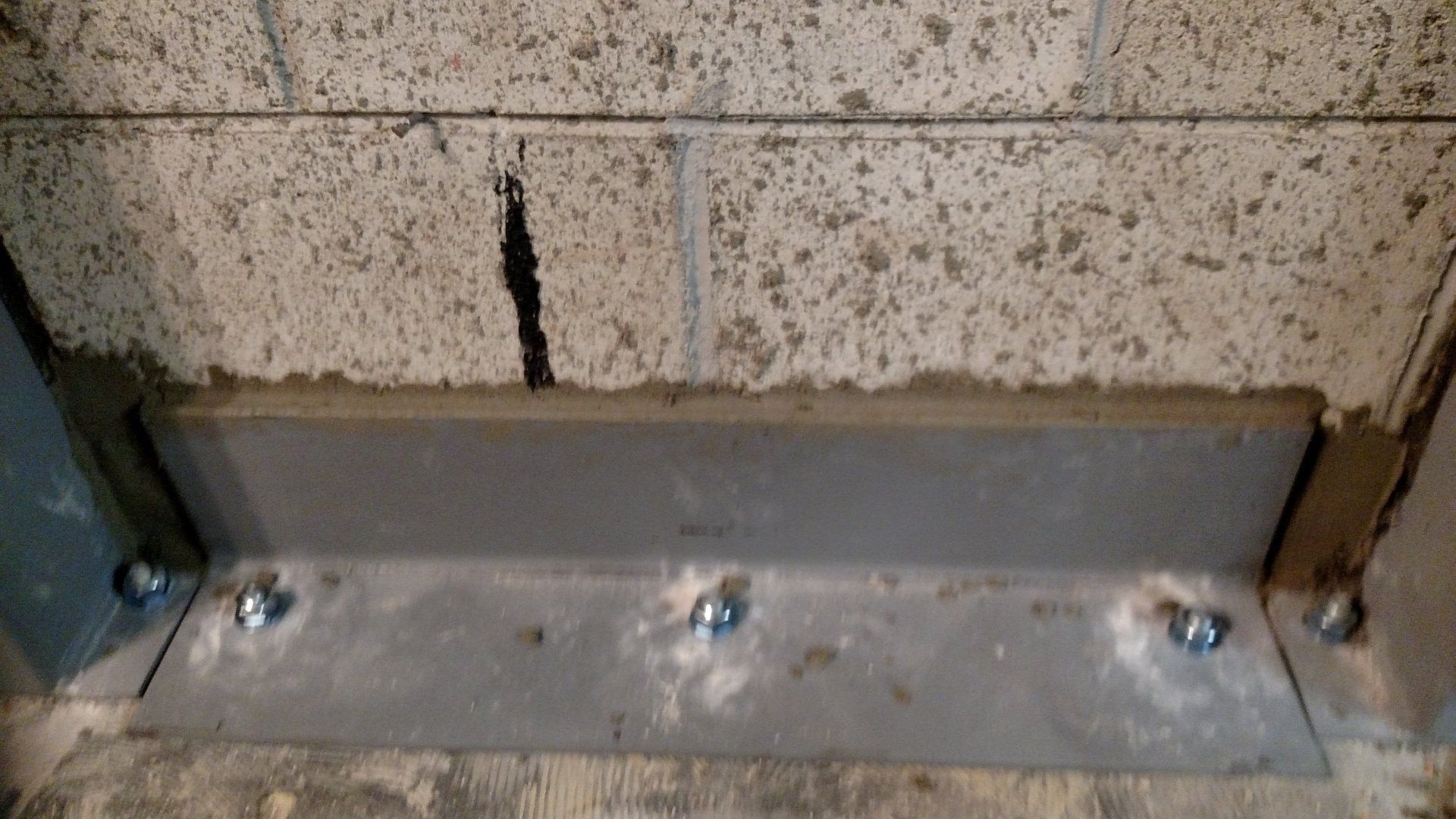 basement repair A metal bracket is attached to a brick wall.