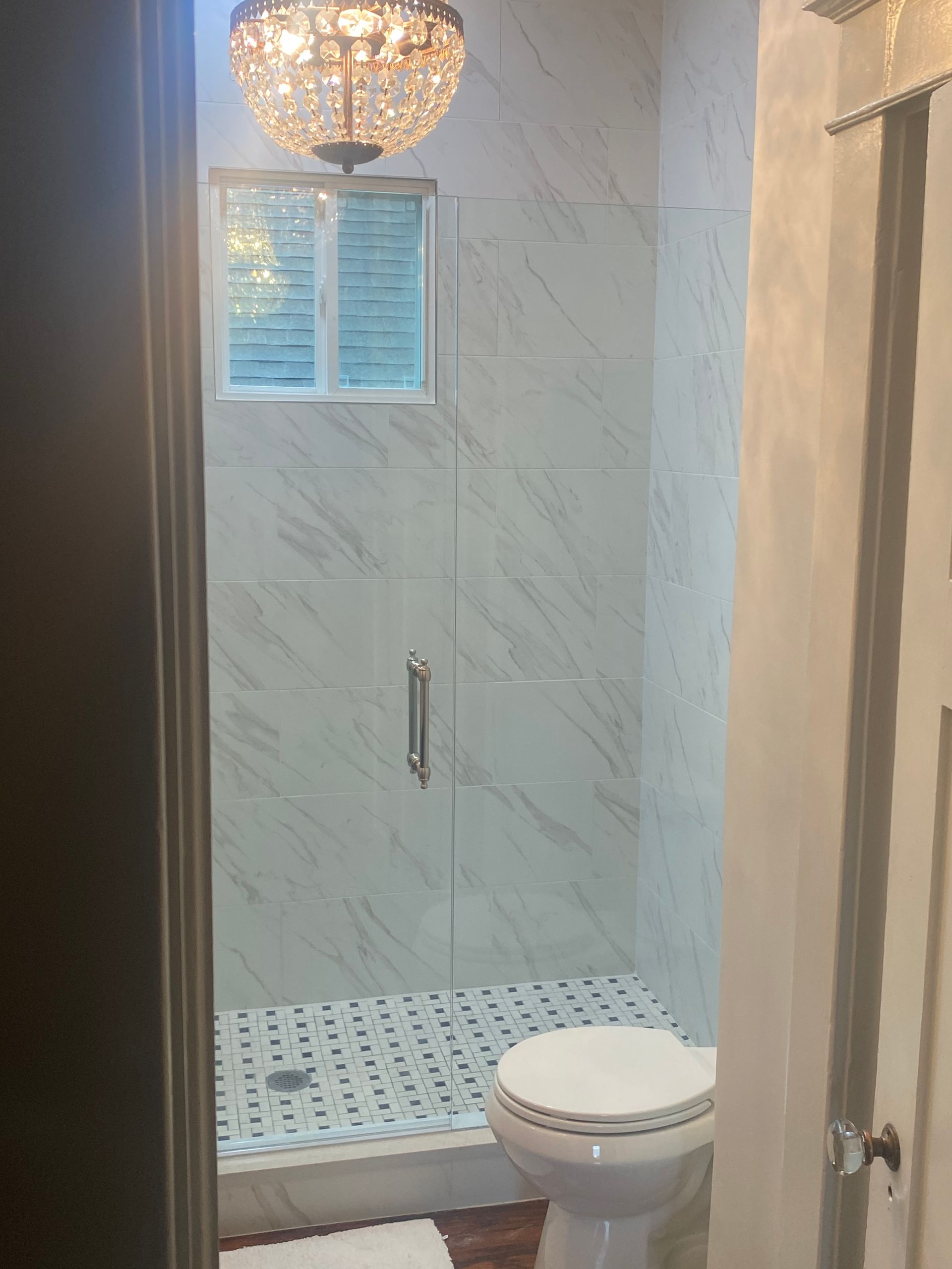 A Bathroom with A Toilet and A Shower with A Chandelier Above It - New Orleans, LA - The Clear Choice