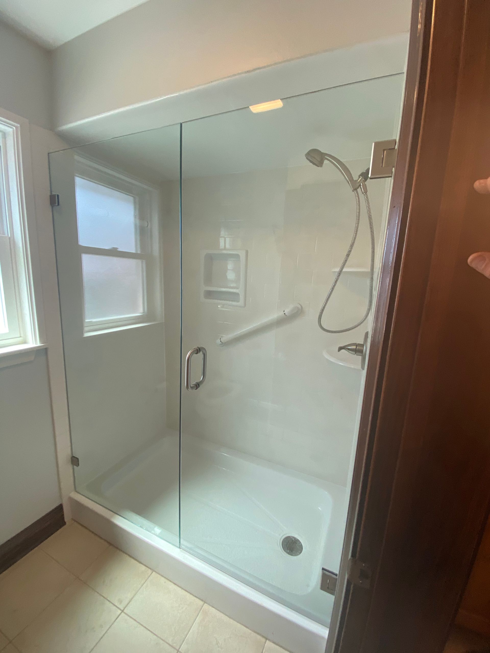 A Bathroom with A Walk-in Shower with A Glass Door and A Window - New Orleans, LA - The Clear Choice