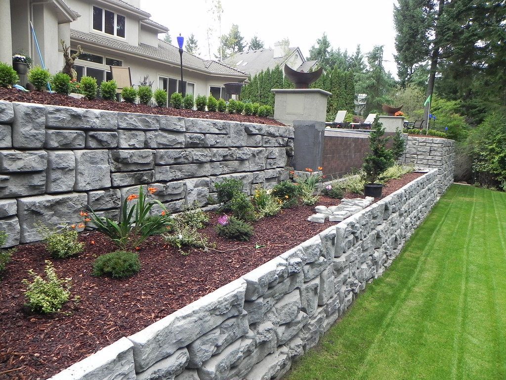 Concrete Retaining wall holding red dirt and landscape
