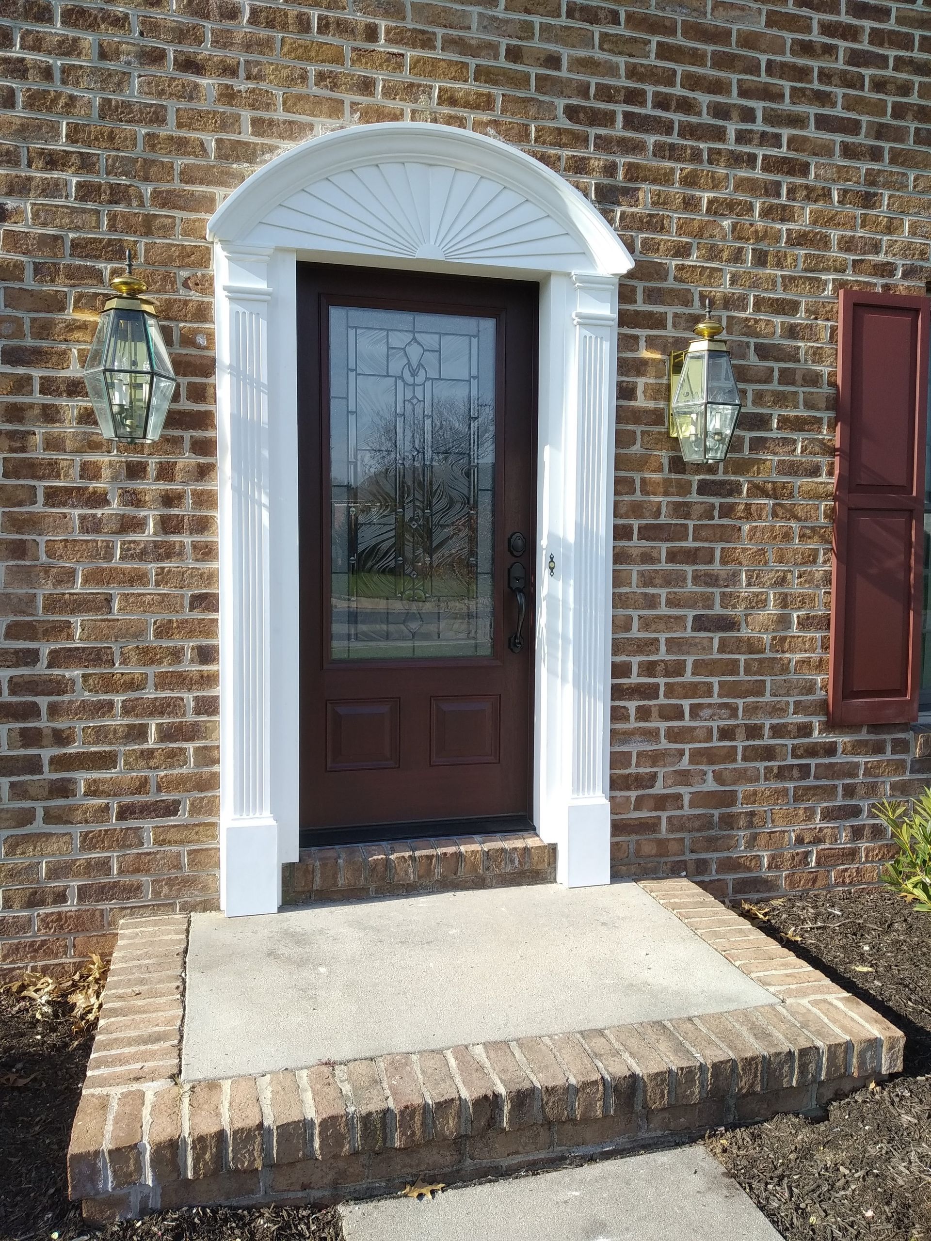 wooden front door with glass panel and architraves around the door