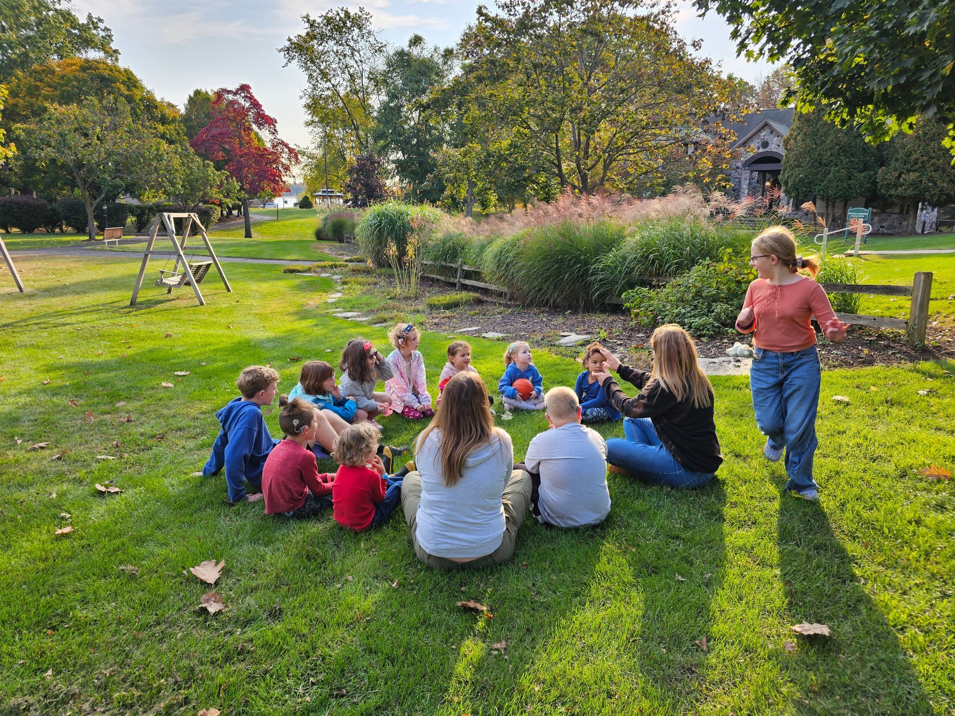 A group of people are jumping in the air in a park.