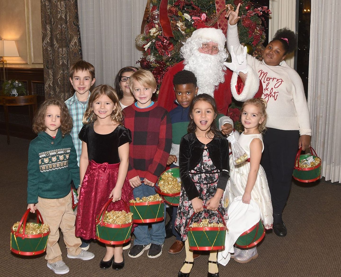 Group of children with Santa smiling at the camera
