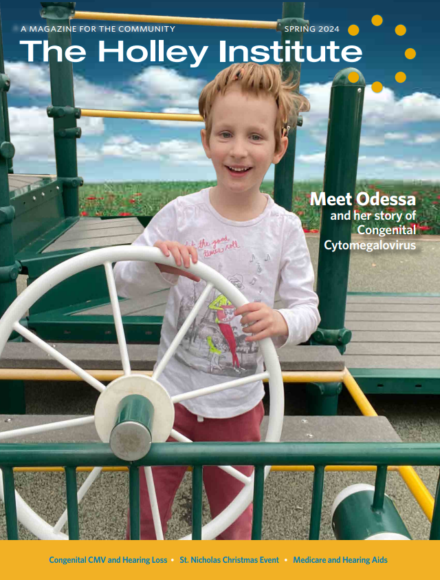 A little girl is holding a steering wheel on a playground.