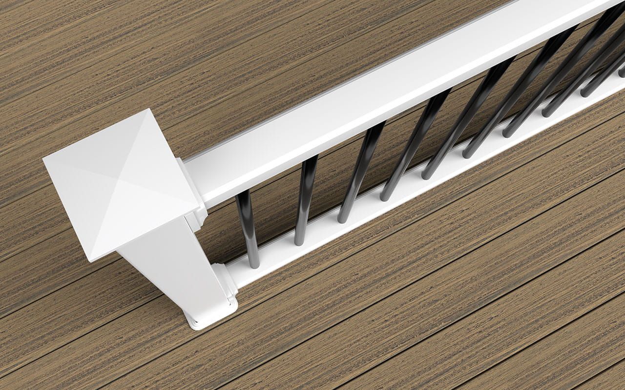 White deck railing with black balusters on brown composite decking.