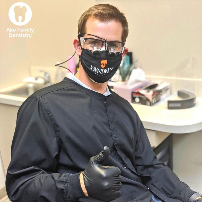 a man wearing a mask and gloves gives a thumbs up
