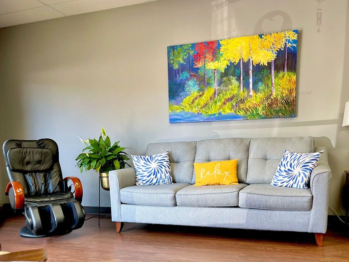 a living room with a couch , chair , and painting on the wall .