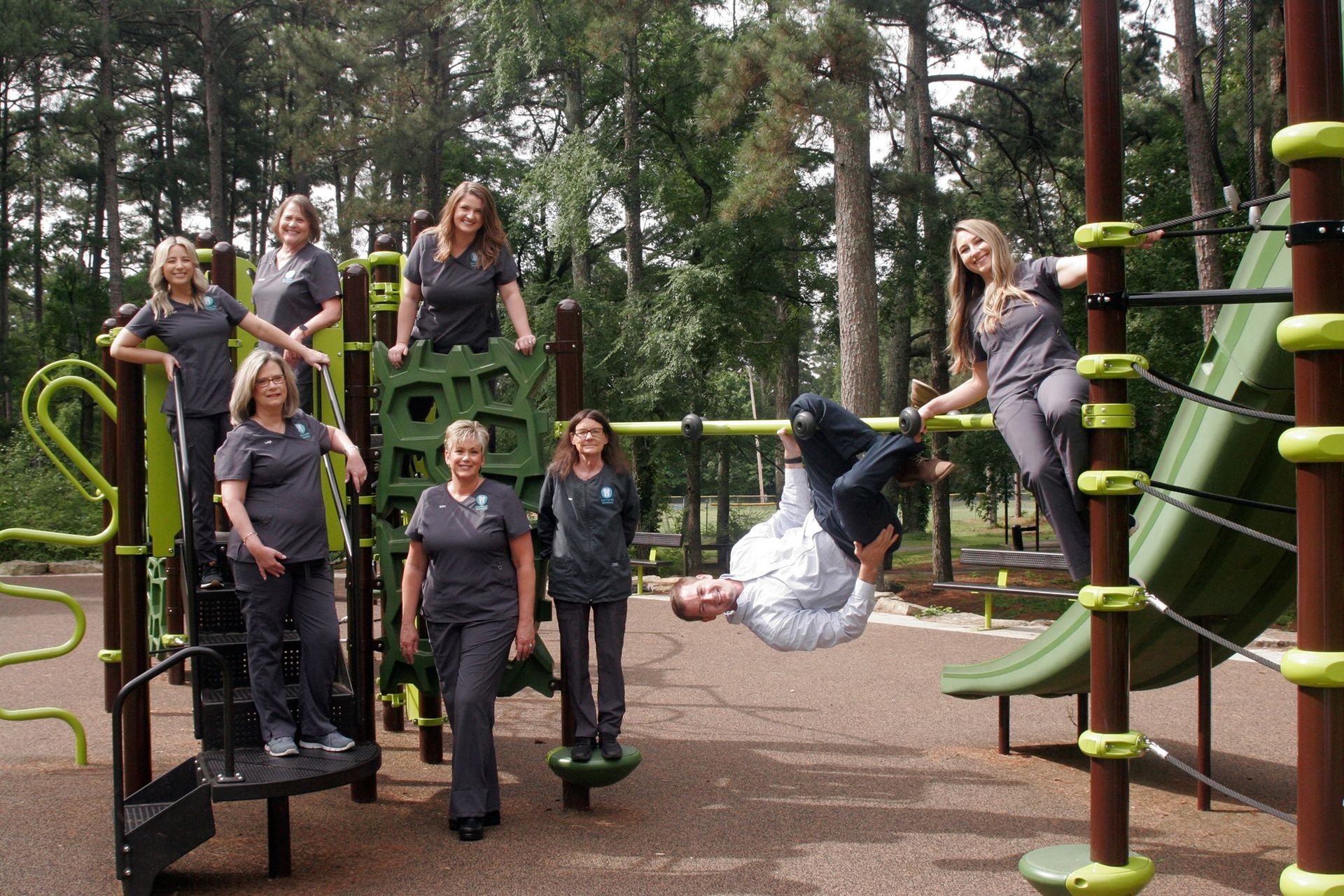 a group of people are posing for a picture on a playground