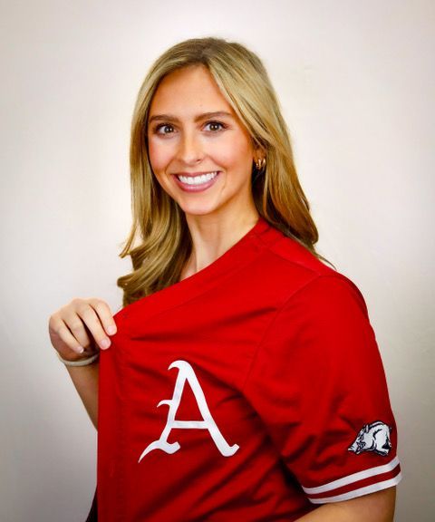 A woman wearing a red jersey with the letter a on it