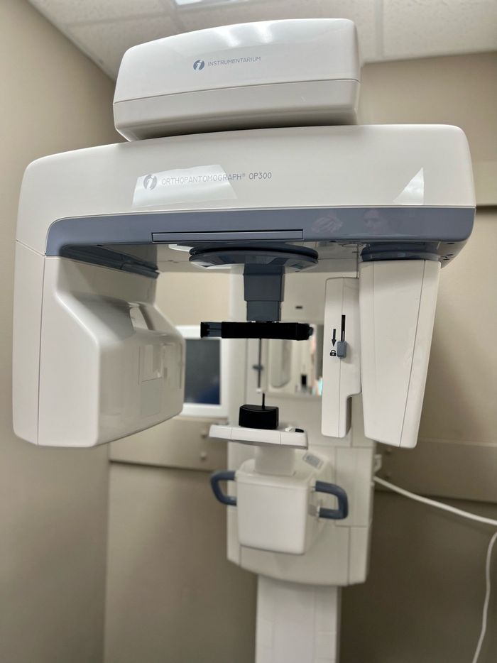 an x-ray machine is sitting in a room next to a wall .
