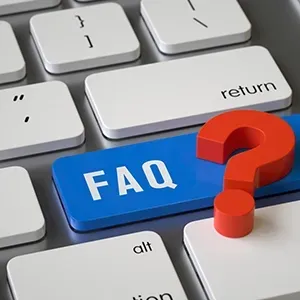 A blue FAQ key with a red question mark on a white computer keyboard.
