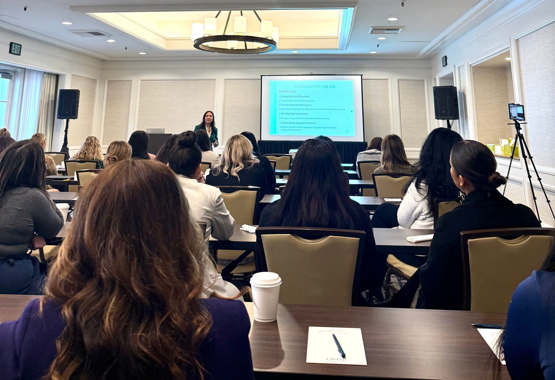 A woman is giving a presentation to a group of people in an auditorium.
