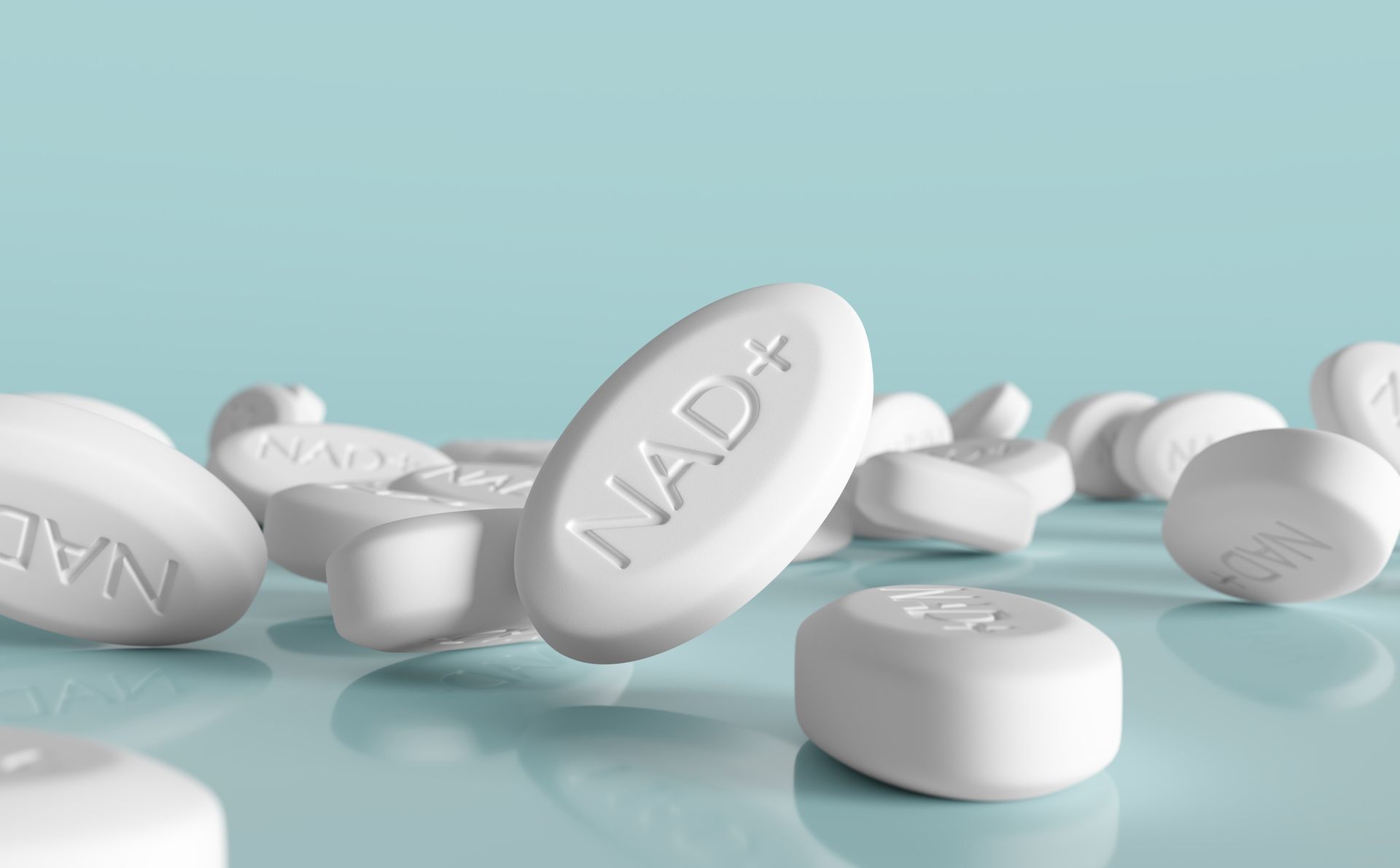A pile of white pills on a blue surface.