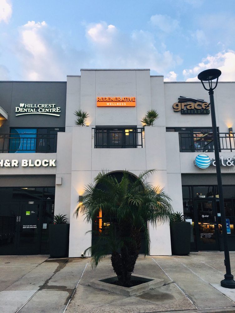 A palm tree is in front of a building that says her block