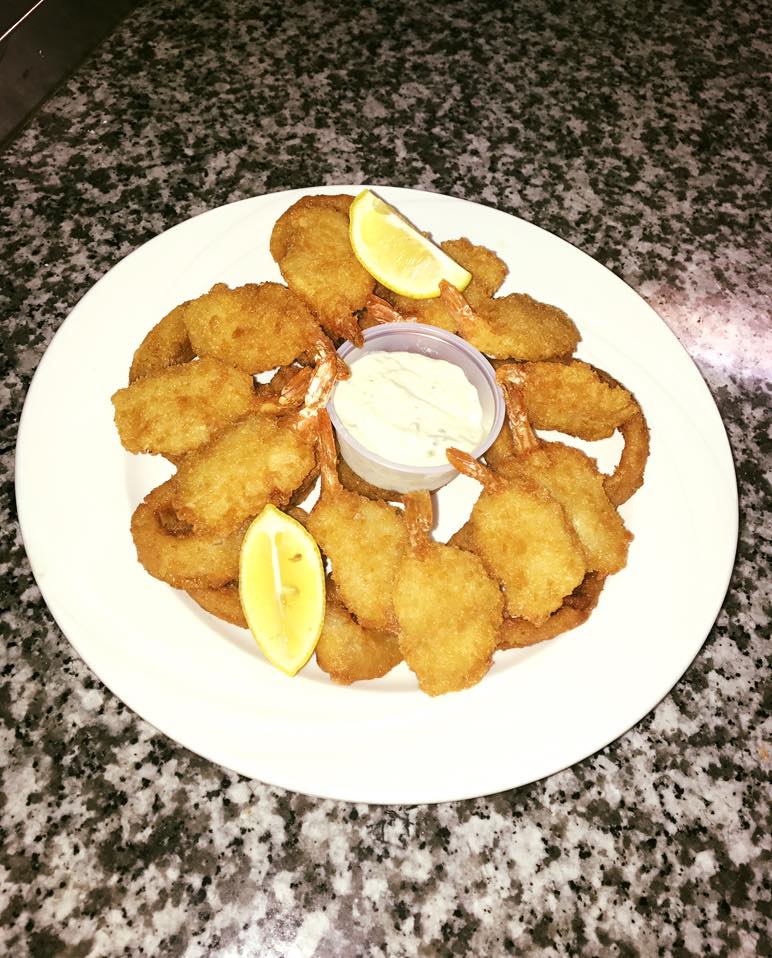 A white plate topped with fried shrimp and lemon slices.