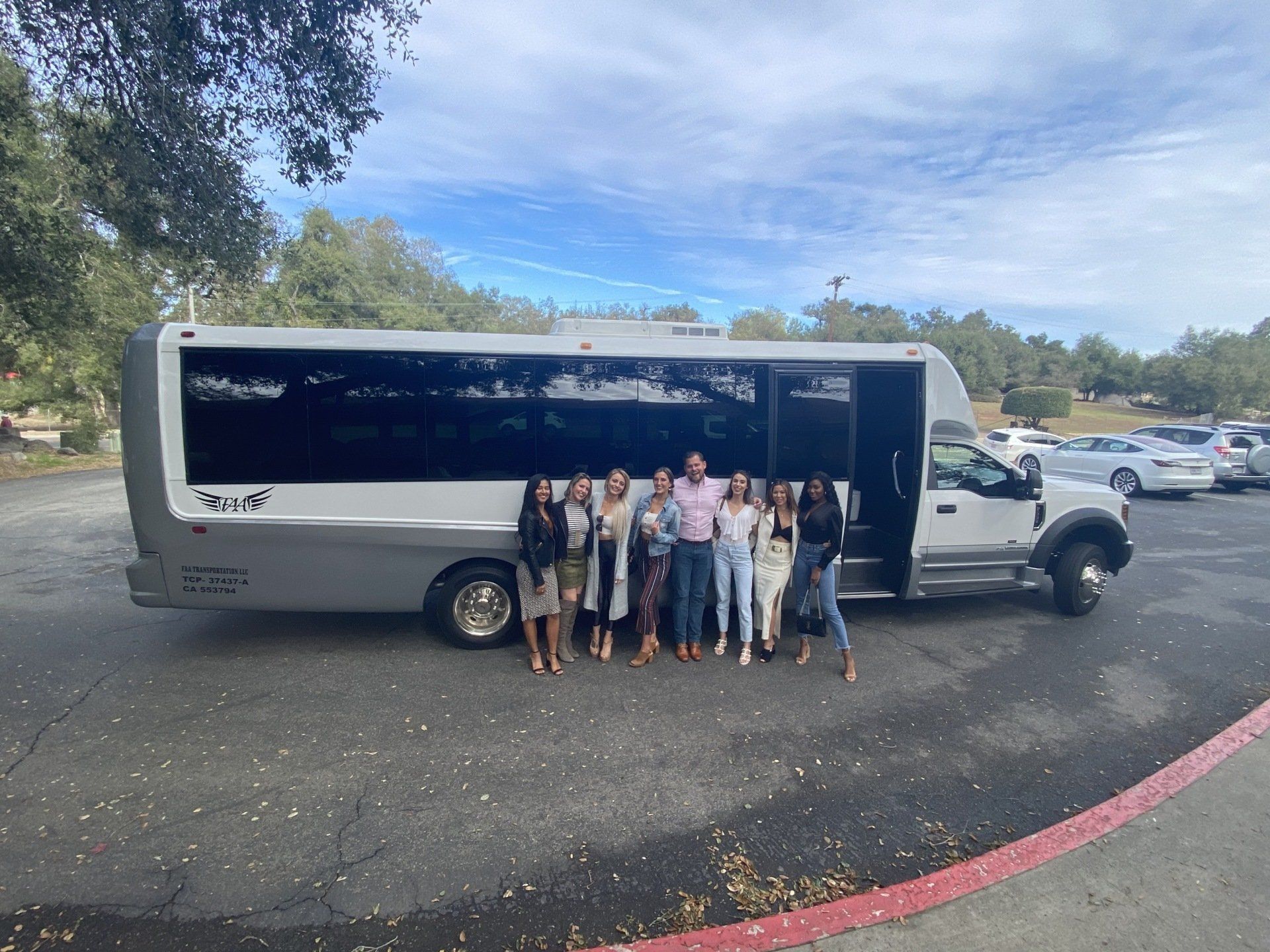 a group of people are posing for a picture in front of a shuttle bus .