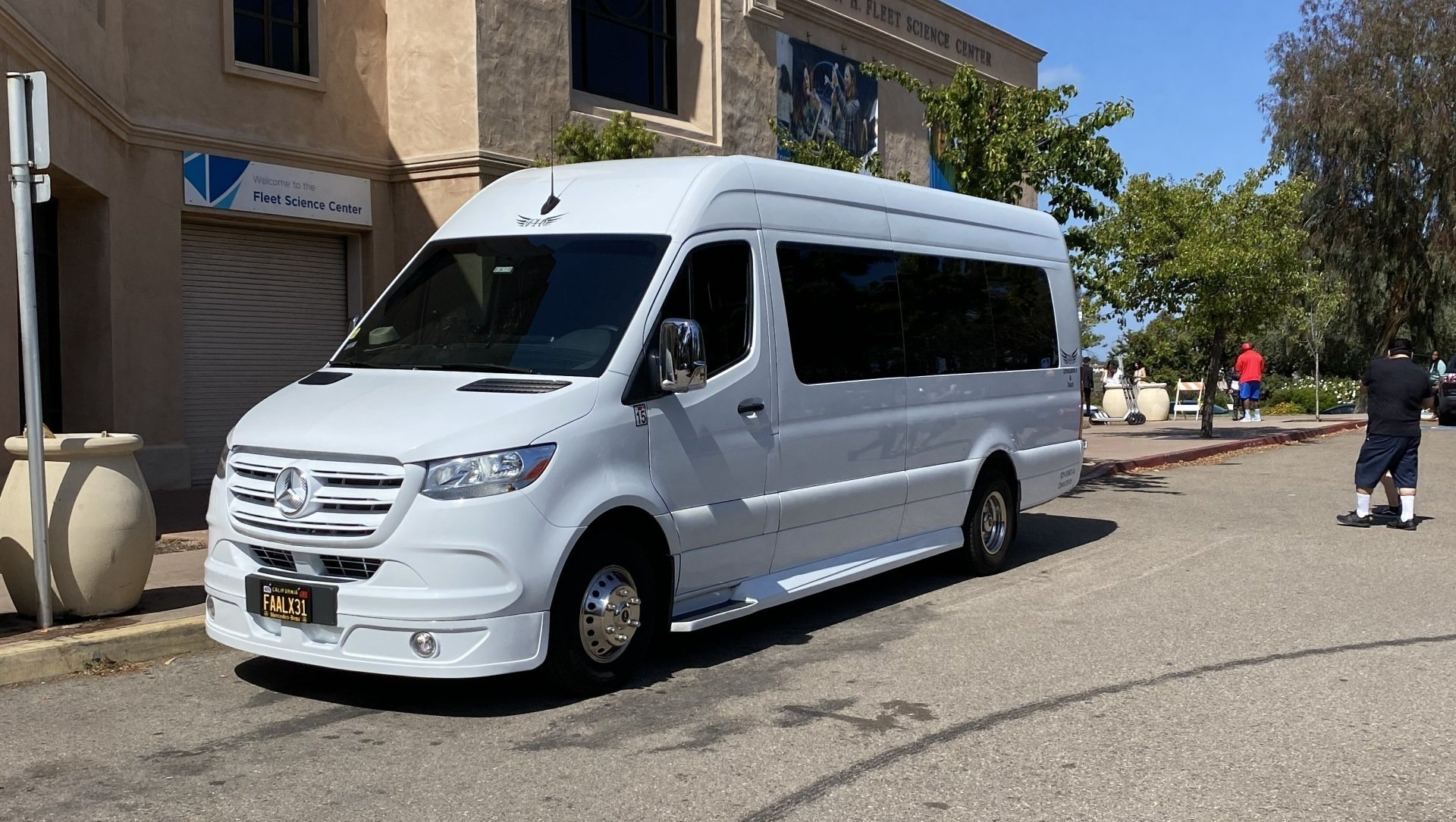 a white van is parked on the side of the road in front of a building .