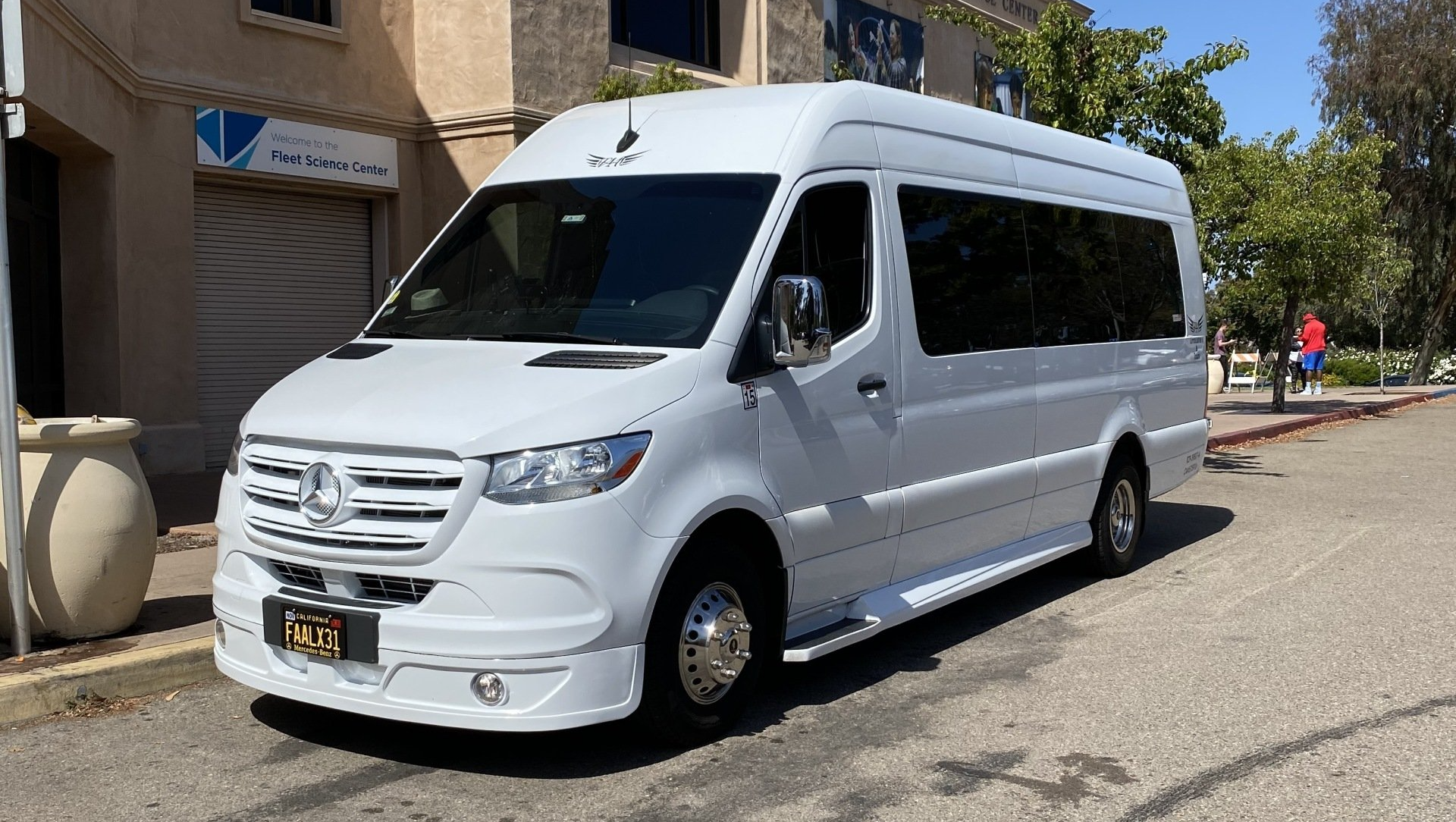 a white van is parked on the side of the road in front of a building .