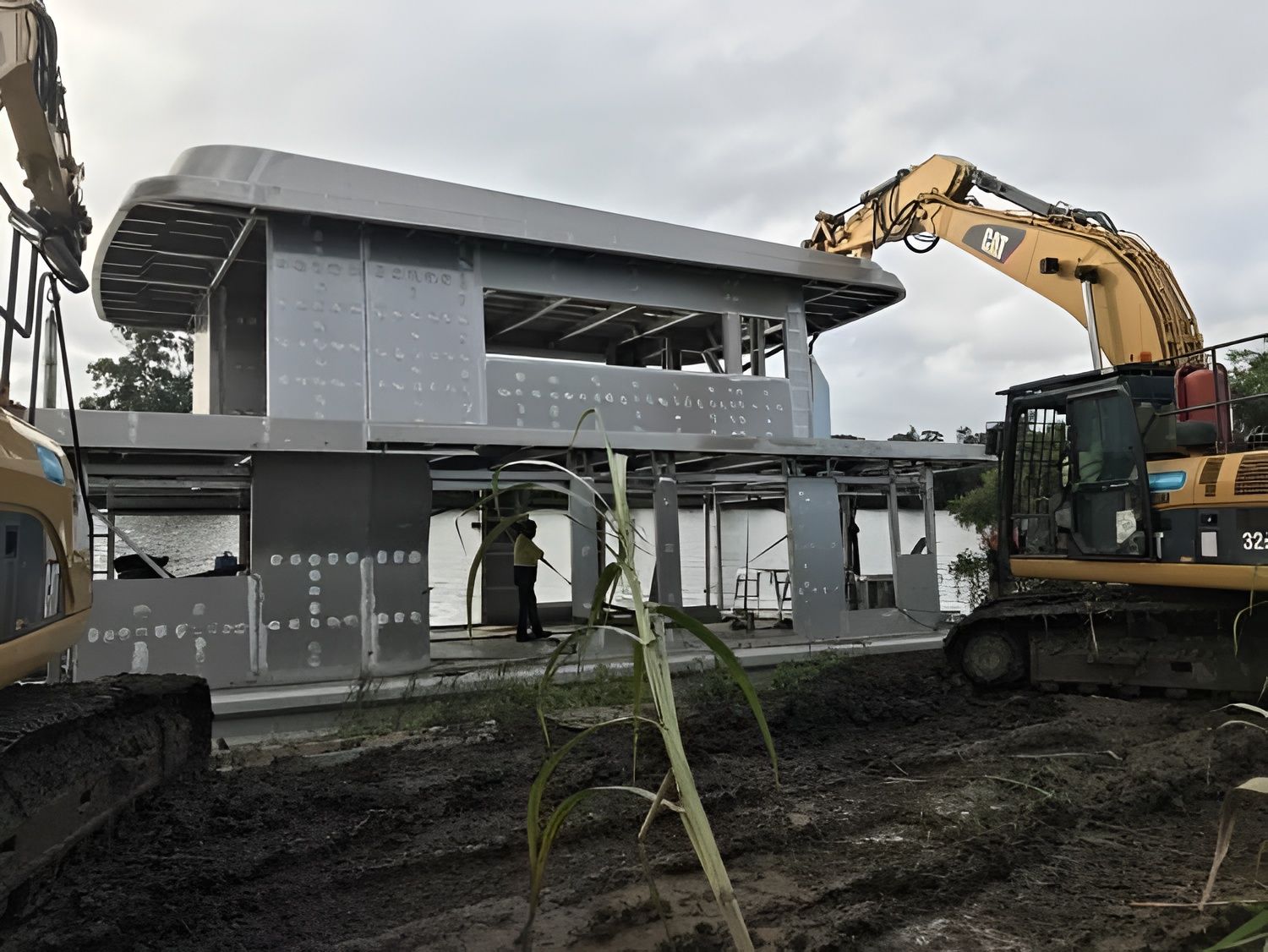 Construction Site With Excavator Placing a Structure — Compass Equipment Hire in Woodburn, NSW